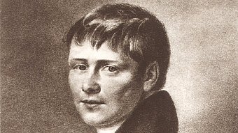 Schwarz-weiße Linienzeichnung eines jungen Mannes mit kurzem, leicht gewelltem Haar und ernstem Gesichtsausdruck. Er trägt einen dunklen, hochgeschlossenen Mantel und ein weißes Halstuch. Der Oberkörper ist leicht zur Seite gedreht, der Blick ist nach vorn gerichtet. Der Hintergrund ist einfarbig und ohne Details.