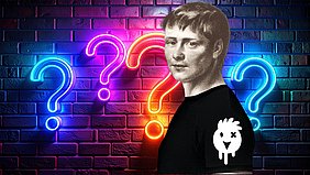 Eine Person steht seitlich vor einer Backsteinwand, die von leuchtenden, farbigen Fragezeichen in Neonoptik dominiert wird. Die Person trägt ein schwarzes T-Shirt mit einem weißen, stilisierten Huhn-Logo auf dem Ärmel. Die Szene wirkt durch die kräftigen Neonfarben und das grafische Element auf dem T-Shirt modern und auffällig.