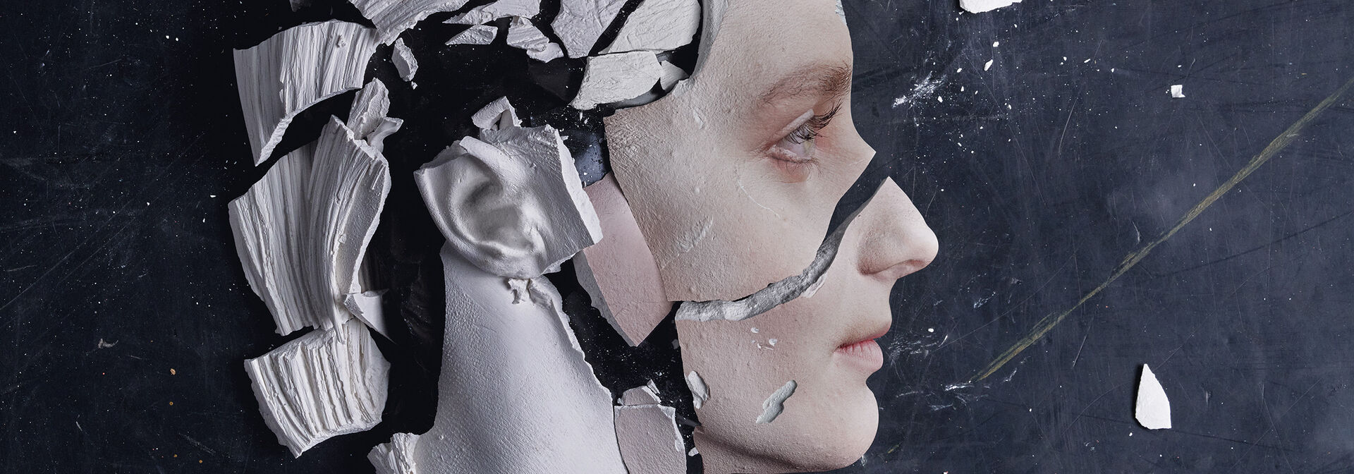 futuristisch anmutender Frauenkopf, der am Hinterkopf in zerbrochenes Porzellan übergeht